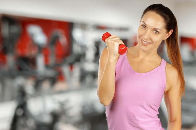 Mujer joven muscular que presenta en la ropa de deportes aislada