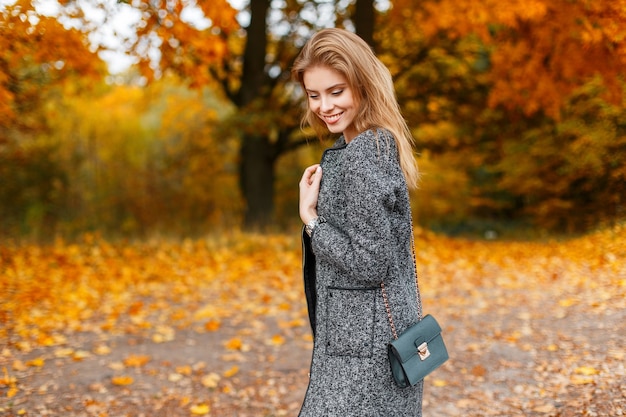 Mujer joven muy hermosa alegre con abrigo gris de moda