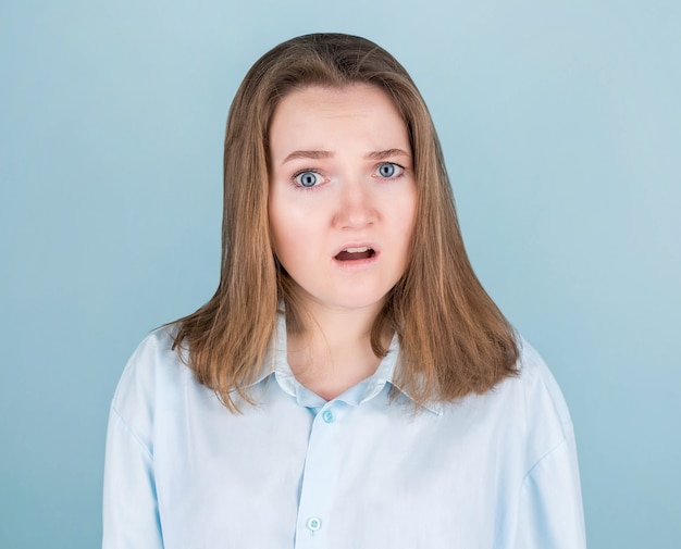 Mujer joven muy sorprendida en azul