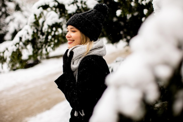 Mujer joven n ropa de abrigo disfrutando en la nieve