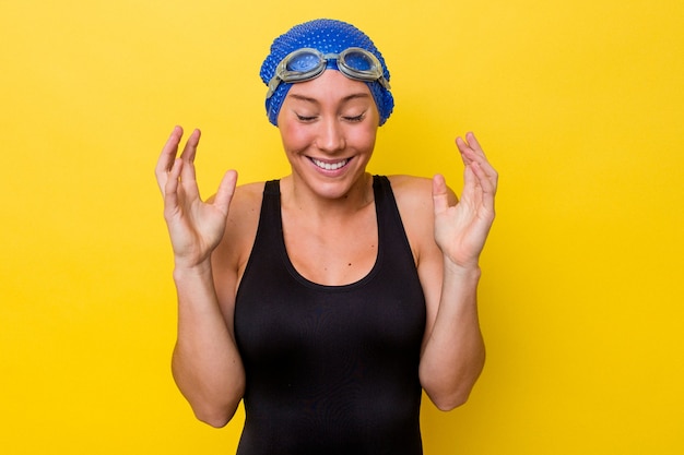 Mujer joven nadador australiano aislada sobre fondo amarillo alegre riendo mucho. Concepto de felicidad.