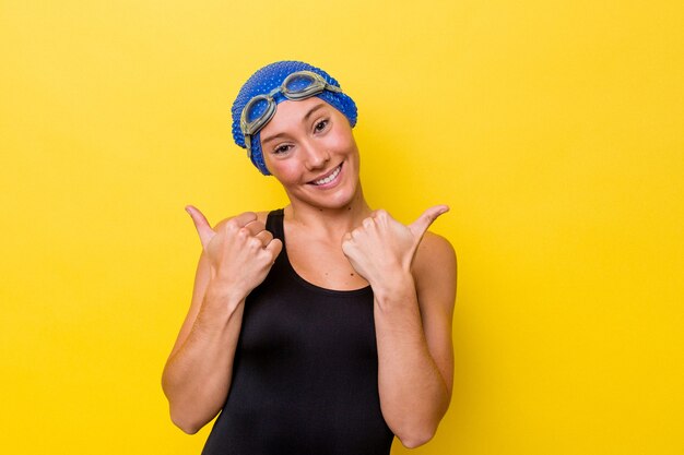 Foto mujer joven nadador australiano aislada sobre fondo amarillo levantando ambos pulgares, sonriendo y confiado.