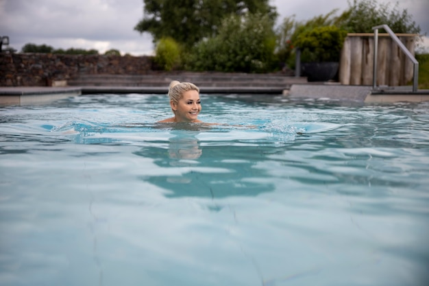 Mujer joven nadando en una piscina en un hotel spa