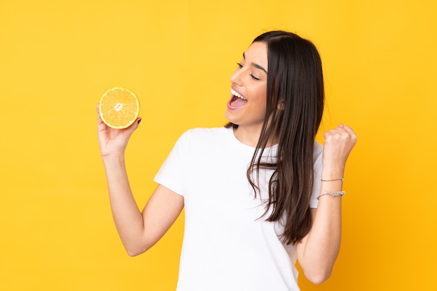 Foto mujer joven con una naranja