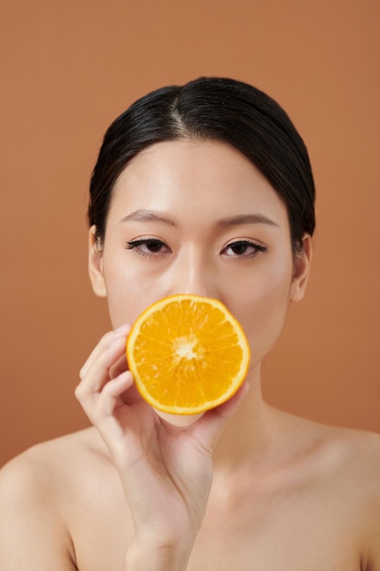 Mujer joven con naranja