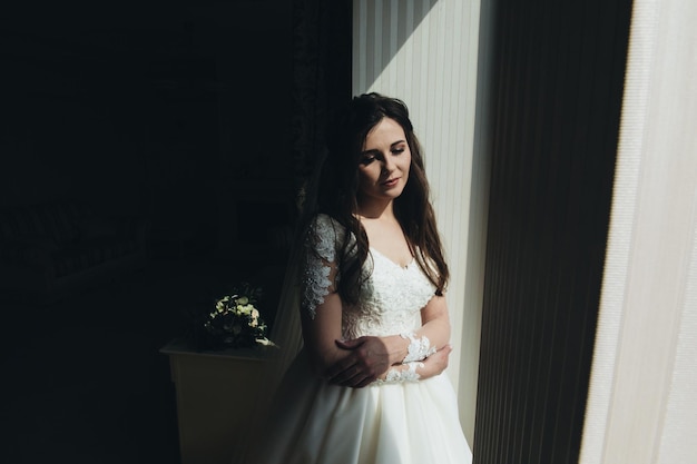 mujer joven novia probándose un vestido de novia en una boda moderna, feliz y sonriente