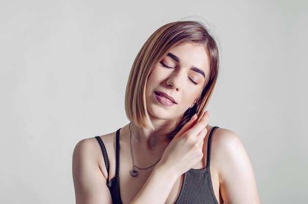 Foto mujer joven con los ojos cerrados contra la pared