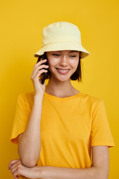 Mujer joven optimista en camiseta amarilla posando moda en fondo aislado de Panamá