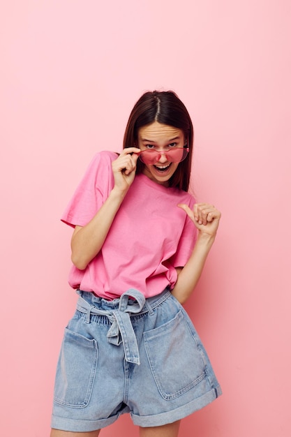 Mujer joven optimista en una camiseta rosa ropa casual estilo de vida inalterado