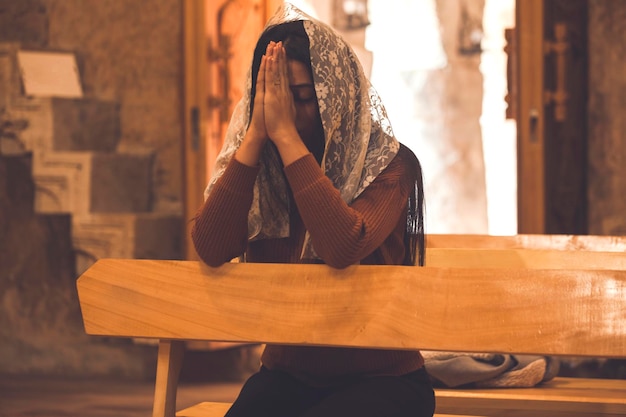 Mujer joven de oración en la iglesia