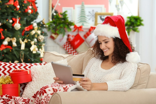 Mujer joven ordenando regalos de Navidad en línea