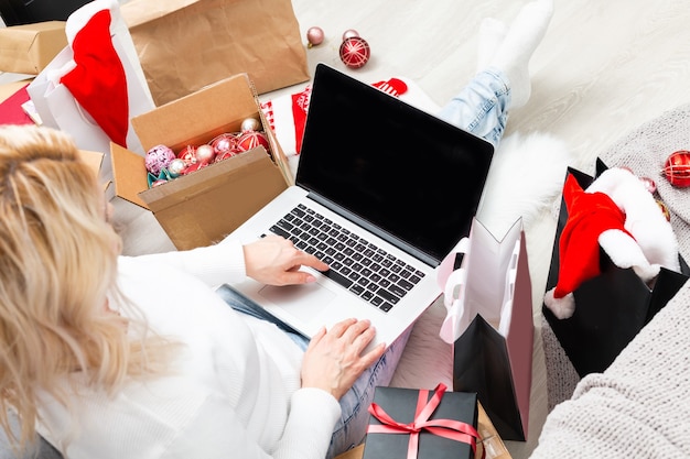 Mujer joven ordenando regalos de Navidad en línea