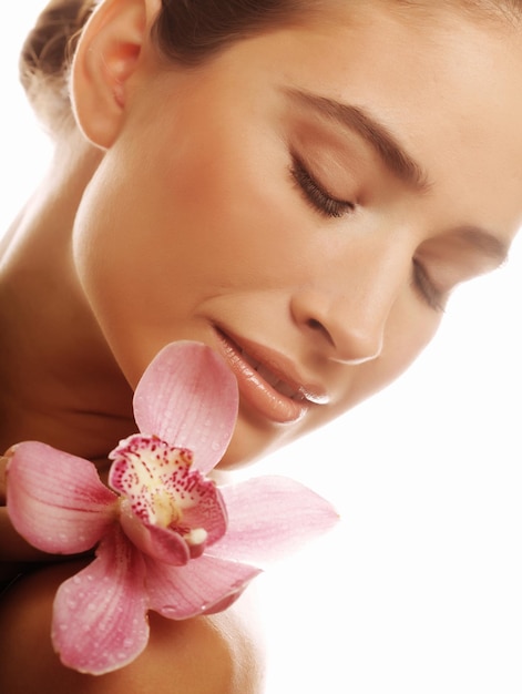 Mujer joven con orquídea rosa