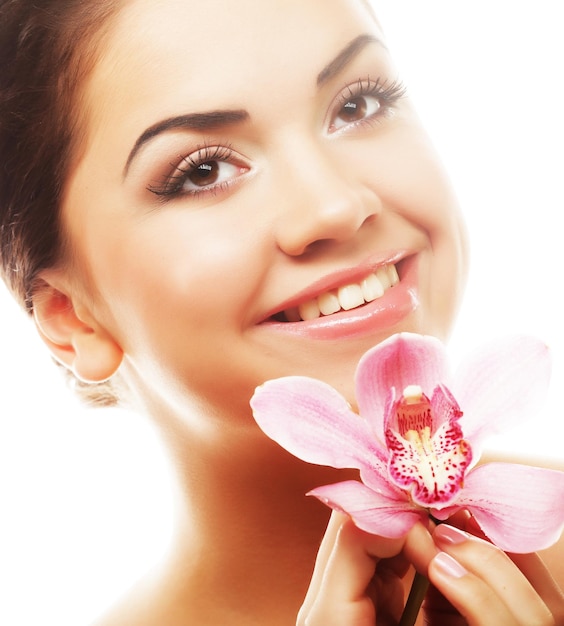 Foto mujer joven con orquídea rosa