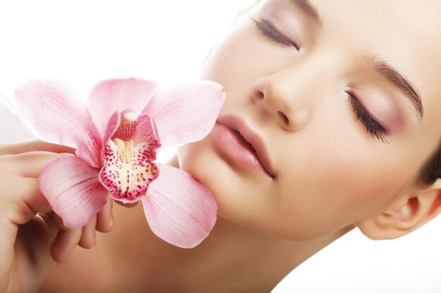 Mujer joven con orquídea rosa