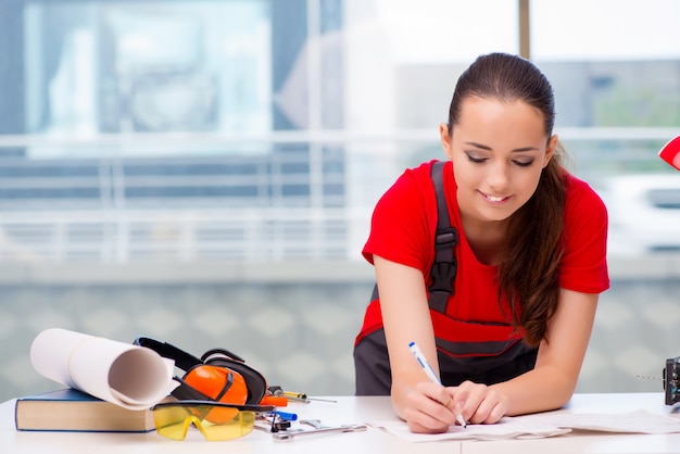 Mujer joven en overoles haciendo reparaciones