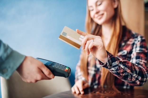 Foto mujer joven pagando con tarjeta de crédito en el café