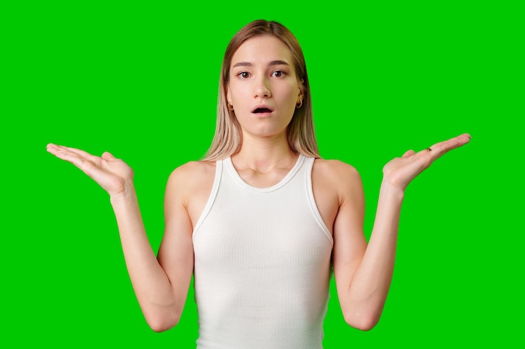 Foto mujer joven con las palmas abiertas gestando con sorpresa contra la pantalla verde