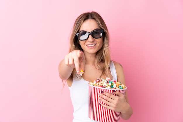 Mujer joven con palomitas de maíz sobre pared aislada