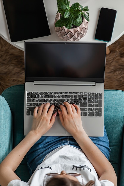 Mujer joven con pantalla de ordenador portátil en blanco, trabajar en casa