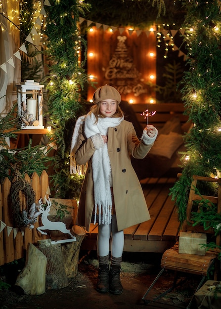 Una mujer joven con un pañuelo blanco con una bengala en una glorieta navideña de estilo escandinavo