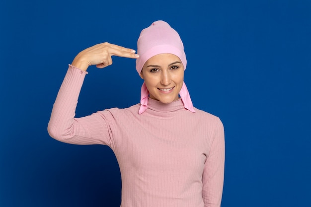 Foto mujer joven con pañuelo rosa en la cabeza sobre un azul