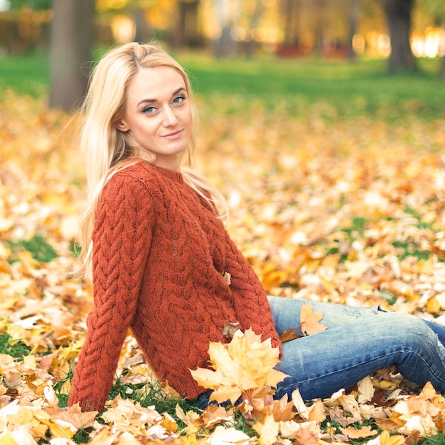 Mujer joven en el parque en día de otoño