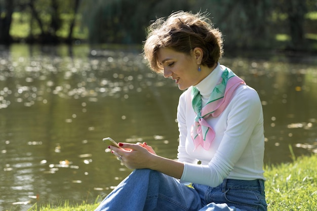 Mujer joven en el parque habla por teléfono móvil Linda chica retrato en estilo francés