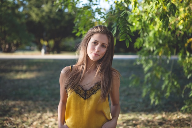 Mujer joven en un parque de otoño, sonriendo a la cámara