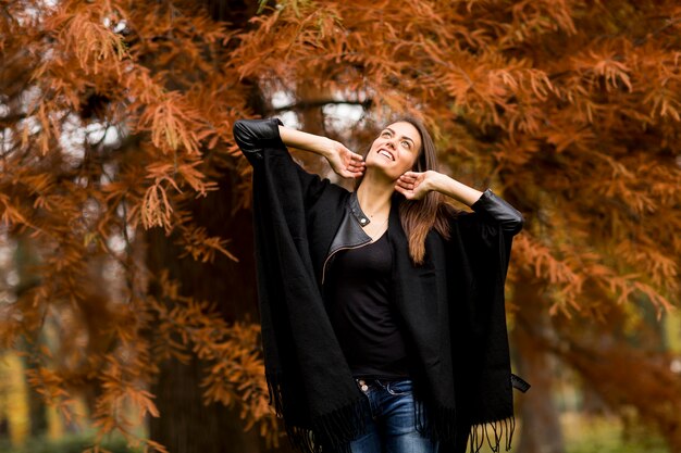 Mujer joven en el parque de otoño