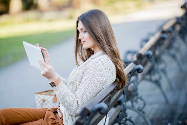 Foto mujer joven en el parque con tableta