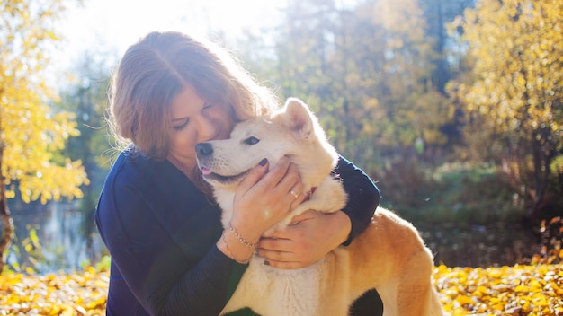 Mujer joven en un paseo con su perro de raza Akita inu