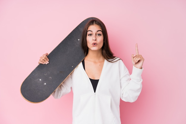 Mujer joven patinadora caucásica con patín con una gran idea, concepto de creatividad.