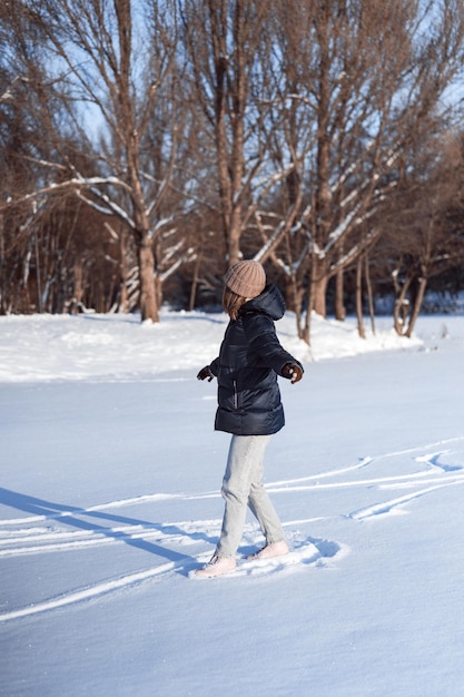 Mujer joven patinaje sobre hielo, deportes de invierno, nieve, diversión de invierno. Mujer aprendiendo a patinar en el lago, naturaleza, día soleado.