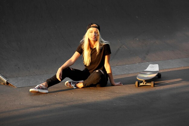 Mujer joven con patineta en la carretera