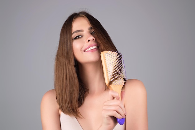 Mujer joven con peine de cabello en el estudio