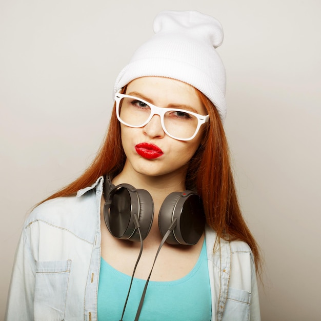 Mujer joven pelirroja con auriculares escuchando música