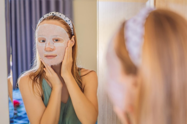 Mujer joven pelirroja haciendo hoja de máscara facial Concepto de belleza y cuidado de la piel