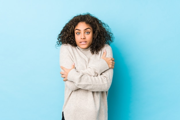 Mujer joven de pelo rizado afroamericano que se enfría debido a la baja temperatura o una enfermedad.