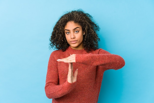 Mujer joven del pelo rizado del afroamericano que muestra un gesto del descanso.