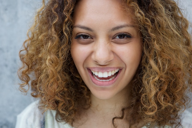 Mujer joven con pelo rizado riendo