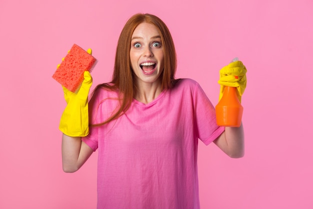 Mujer joven con pelo rojo en guantes de goma amarillos