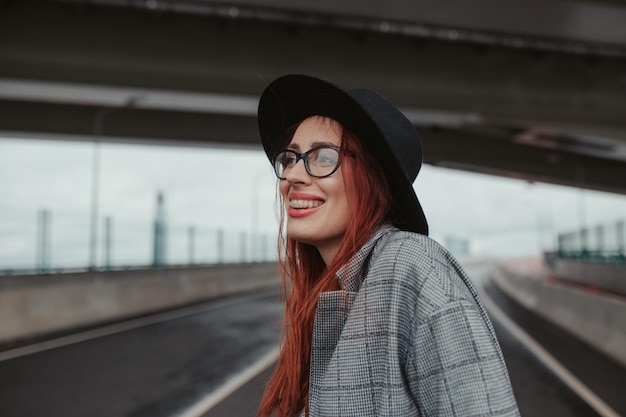 mujer joven con el pelo rojo riendo con aparatos ortopédicos