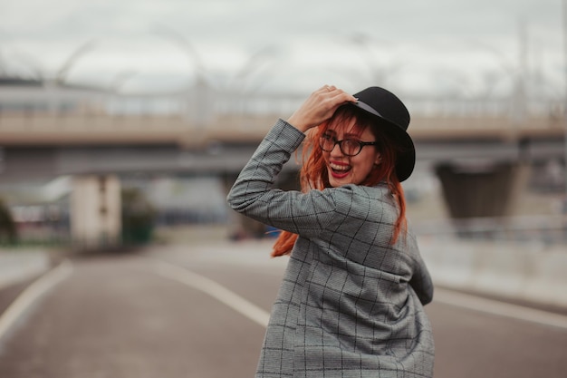 mujer joven con el pelo rojo riendo con aparatos ortopédicos