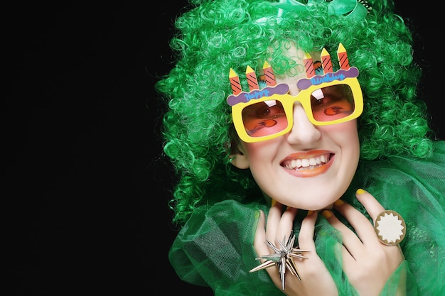 Mujer joven con pelo verde y gafas de carnaval