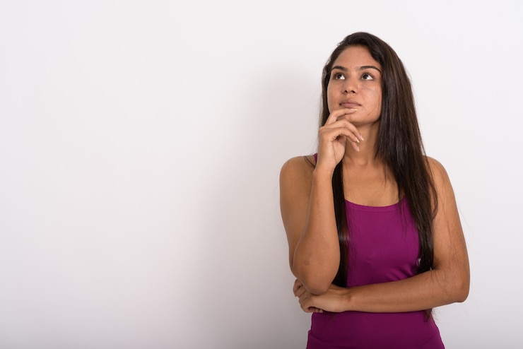 Foto mujer joven pensando mientras mira hacia arriba