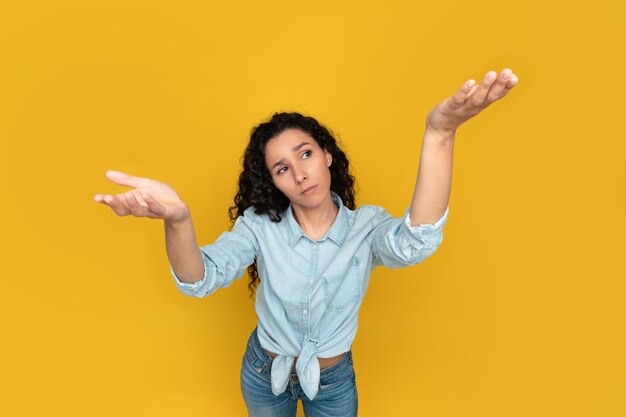 Mujer joven pensativa comparando variantes haciendo escalas con las manos vacías