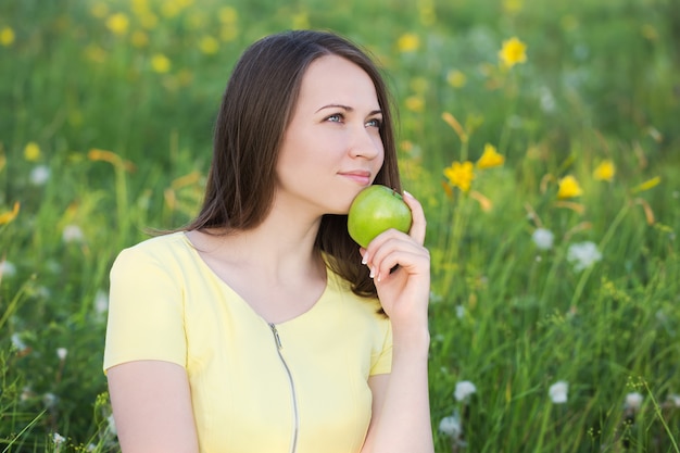 Mujer joven pensativa con manzana