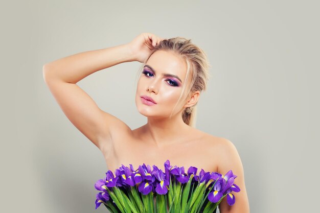 Mujer joven perfecta con la mano sosteniendo flores Concepto de aromaterapia