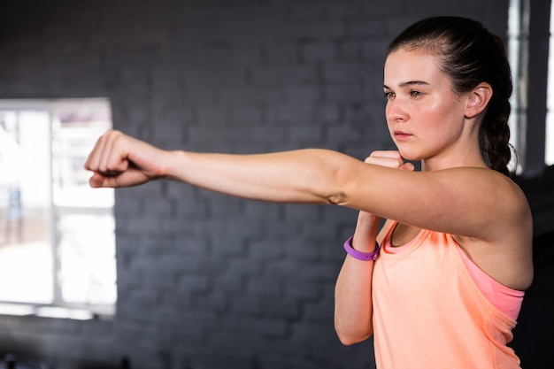 Mujer joven perforando en el gimnasio